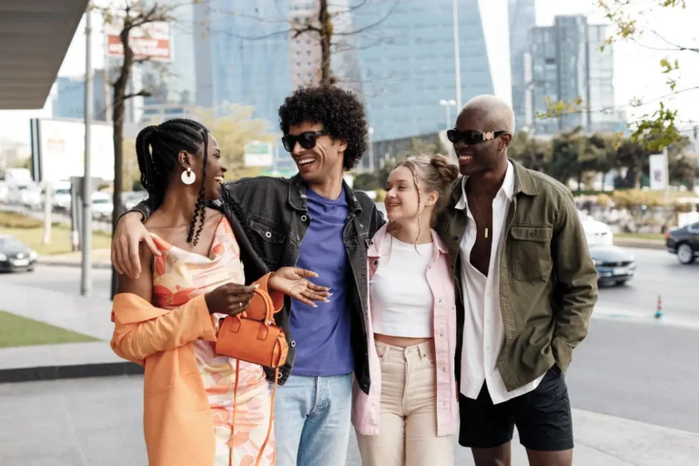 Grupo de jóvenes diversos caminando juntos y sonriendo, representando la diversidad y la inclusión social en el espectro autista