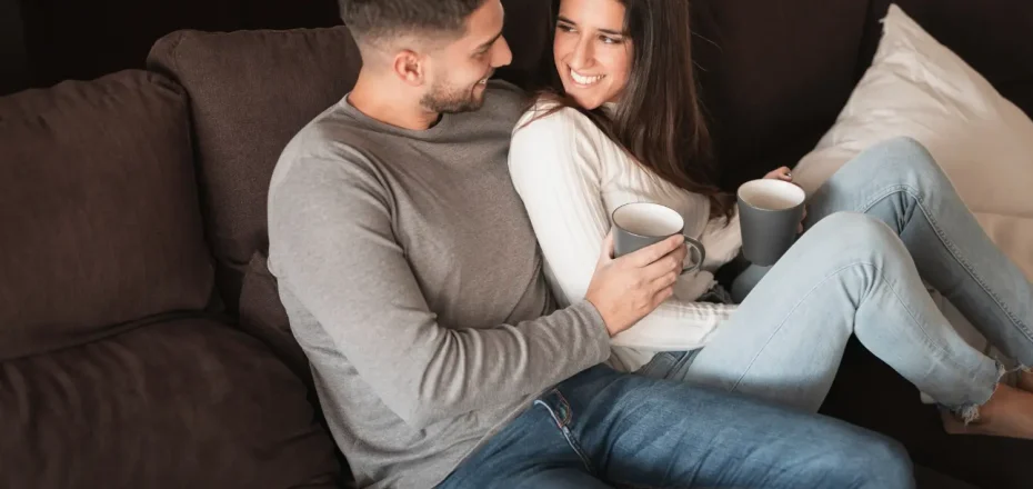 Pareja sentada en el sofá compartiendo un momento de conexión y comunicación afectiva